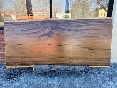 Close-up view of a live edge acacia wood slab dining table top, showcasing its natural wood grain, rich tones, and unique, irregular edges that highlight the organic beauty of the wood