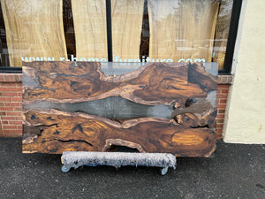 A Live Edge Dining Table Top made from Ironwood, featuring a rich, dark wood grain with natural, raw edges, complemented by an opaque black epoxy resin filling that contrasts beautifully with the wood. The epoxy creates a sleek, modern finish, highlighting the unique characteristics of the wood while adding a contemporary touch.
