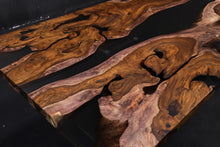 A Live Edge Dining Table Top made from Ironwood, featuring a rich, dark wood grain with natural, raw edges, complemented by an opaque black epoxy resin filling that contrasts beautifully with the wood. The epoxy creates a sleek, modern finish, highlighting the unique characteristics of the wood while adding a contemporary touch.