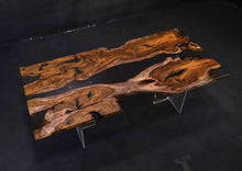 A Live Edge Dining Table Top made from Ironwood, featuring a rich, dark wood grain with natural, raw edges, complemented by an opaque black epoxy resin filling that contrasts beautifully with the wood. The epoxy creates a sleek, modern finish, highlighting the unique characteristics of the wood while adding a contemporary touch.