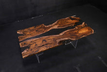 A Live Edge Dining Table Top made from Ironwood, featuring a rich, dark wood grain with natural, raw edges, complemented by an opaque black epoxy resin filling that contrasts beautifully with the wood. The epoxy creates a sleek, modern finish, highlighting the unique characteristics of the wood while adding a contemporary touch.